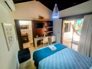 a bedroom with a blue bed and a desk at Villa Bangalu in Porto De Galinhas