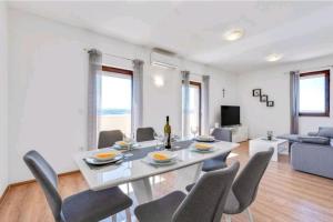 a dining room with a white table and chairs at HOLIDAY HOME LUANA in Maslenica
