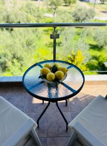 una mesa de cristal con un tazón de limones. en Villa Spartandom, en Gerakini