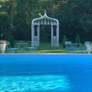 einen Pavillon und Stühle neben einem Pool in der Unterkunft Chateau Mas de Pradie B&B Fountain view room in Foissac