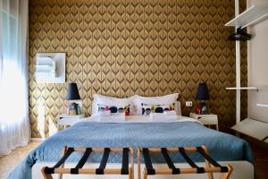 a bedroom with a large bed with two chairs at GUEST HOUSE SONNINO 37 in Cagliari