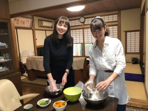 two women standing in a kitchen preparing food at KOTO TEA HOUSE - Vacation STAY 12837 in Kumamoto