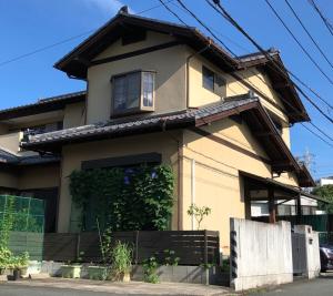 a yellow house with a fence in front of it at KOTO TEA HOUSE - Vacation STAY 12837 in Kumamoto