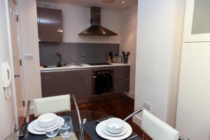 a kitchen with a table and chairs and a kitchen with a sink at AA City Apartments in Newcastle upon Tyne