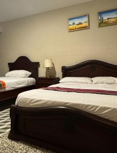 1 dormitorio con 2 camas y lámpara. en Hostal La Casta en Camarones
