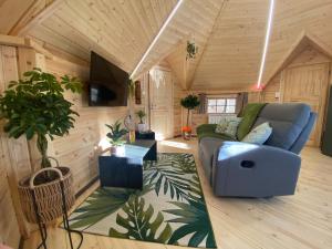 sala de estar con sofá azul y TV en Le Tiki de Coucou, en Foncine-le-Haut
