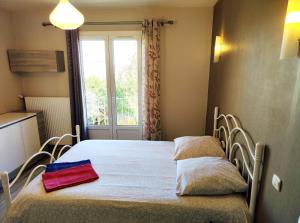 1 cama con 2 almohadas en una habitación con ventana en Le PATIO GARONNE maison 6 personnes, climatisé, Netflix, en Portet-sur-Garonne