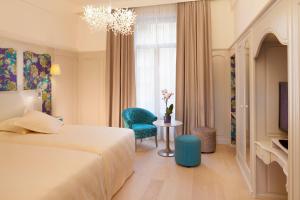 a bedroom with a bed and a table and a chandelier at Oceania L'Univers Tours in Tours