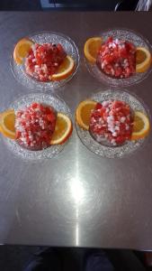 cuatro tazones de vidrio de frutas con caviar rojo y rodajas de naranja en Kasbah Tialouite, en Kalaat MGouna