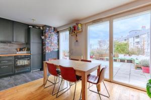 - une cuisine avec une table et des chaises en bois dans l'établissement Résidor - Sublime Appartement avec terrasse, à Saint-Ouen