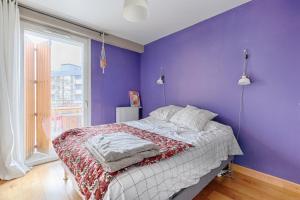 - une chambre dotée d'un lit avec un mur violet dans l'établissement Résidor - Sublime Appartement avec terrasse, à Saint-Ouen
