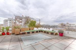 d'un toit-terrasse avec des bancs et des plantes. dans l'établissement Résidor - Sublime Appartement avec terrasse, à Saint-Ouen