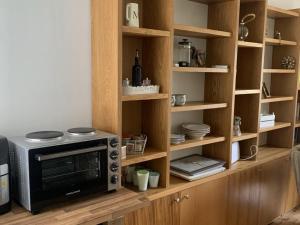 a microwave oven sitting on top of a wooden shelf at Charming 1-Bed Apartment in Alfreton in Alfreton