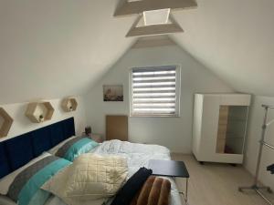 een slaapkamer op zolder met een bed en een raam bij A comfortable holiday home in Stepniczka in Stepnica