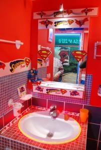 a bathroom with a sink and a red wall at Comics Factory Airport & City in Catania