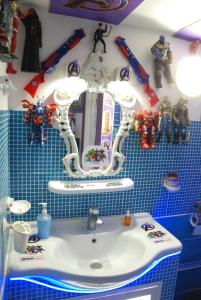 a bathroom with a sink and some toys on the wall at Comics Factory Airport & City in Catania