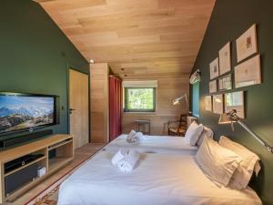a bedroom with two beds and a flat screen tv at Chalet Argentière, 8 pièces, 14 personnes - FR-1-343-243 in Chamonix
