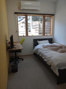 Naoshima Accommodation Menjuku Ura - Vacation STAY 25585v في ناووشيما: غرفة نوم بسرير ومكتب ونافذة