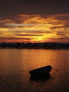 a boat in the water with a sunset in the background at Ninos K.Guraidhoo in Guraidhoo