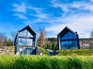 a house with two large windows on top of a field at U Boku Stoku in Kasina Wielka