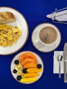 a table with plates of food and a cup of coffee at Hotel Boutique Iyarí in Palmira