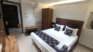 um quarto com uma cama com almofadas azuis e amarelas em HOTEL SAI PALACE em Gorakhpur
