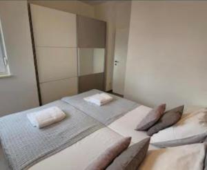 a bedroom with a large bed with two pillows at The Palms Luxury Pool Aparthotel in Novalja