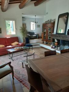 ein Wohnzimmer mit einem roten Sofa und einem Kamin in der Unterkunft Jolie villa provençale avec piscine et vue mer in La Ciotat