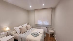 a bedroom with a bed with two towels on it at Apartamento Corbaceiras in Pontevedra