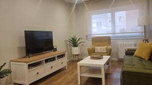 uma sala de estar com uma televisão de ecrã plano num centro de entretenimento em Apartamento Corbaceiras em Pontevedra