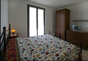 a bedroom with a bed with a flowered blanket at La Mandriana in Massa Marittima