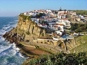 a village on top of a cliff next to the ocean at Casa Jasmim in Sintra