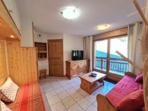 un soggiorno con divano e una grande finestra di Balcon des pistes - 217-218 - Appt tout confort 8p a Les Deux Alpes