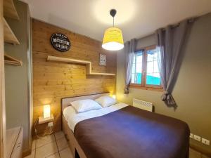 una camera con un letto e una parete in legno di Balcon des pistes - 217-218 - Appt tout confort 8p a Les Deux Alpes
