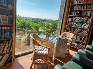 uma biblioteca com uma mesa e cadeiras de vidro e uma janela em Casa de las Lavandas, Ávila em Ávila