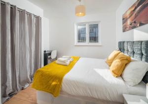 a bedroom with a bed with a yellow blanket on it at Crawley Maunsell Park Charm & Cosy 1 Bedroom Apartment with Parking in Crawley