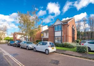 a row of cars parked in front of a house at Crawley Maunsell Park Charm & Cosy 1 Bedroom Apartment with Parking in Crawley