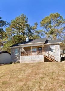 a large brick house with a deck on a field at Brand New 3 bedroom 2 bath Home (Built 2022) in Huntsville