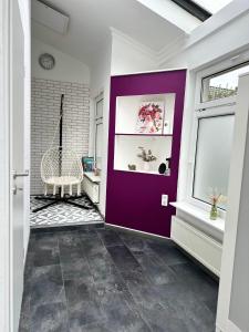 a hallway with a purple wall and a window at Ferienwohnung Steinebach 