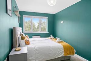 Un dormitorio con una cama con paredes azules y una ventana en Entire 2 Bedroom Luxury Apartment with Free Parking en Milton Keynes
