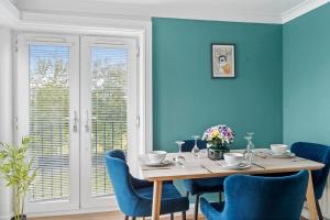 comedor con paredes azules, mesa y sillas en Entire 2 Bedroom Luxury Apartment with Free Parking, en Milton Keynes