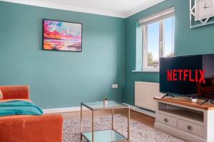 uma sala de estar com uma televisão e um sofá em Entire 2 Bedroom Luxury Apartment with Free Parking em Milton Keynes