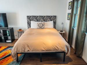 a bedroom with a bed with a yellow comforter at Cozy Guest House Studio Apartment in Greensboro