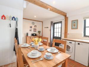 a kitchen and dining room with a wooden table and chairs at The Hayloft in Norwich