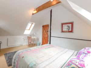 a bedroom with a bed and a desk in a attic at The Hayloft in Norwich