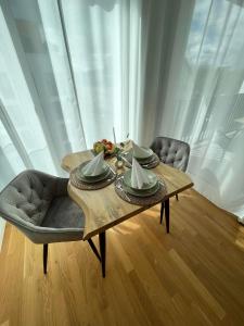 uma mesa de madeira com tigelas e pratos no topo em Queens Peak Apartment em Colônia