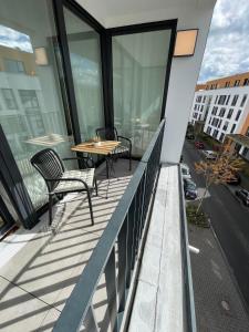 uma varanda com uma mesa e cadeiras num edifício em Queens Peak Apartment em Colônia