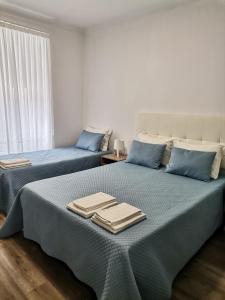 Dos camas en una habitación con toallas. en Baixinho Guest House, en Vila Praia de Âncora