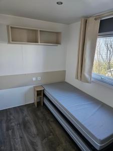 Cette petite chambre comprend un lit et une fenêtre. dans l'établissement Villa Landreau - le fenouiller 85, à Le Fenouiller