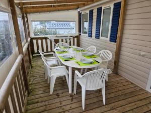 - une table et des chaises sur la terrasse couverte d'une maison dans l'établissement Villa Landreau - le fenouiller 85, à Le Fenouiller